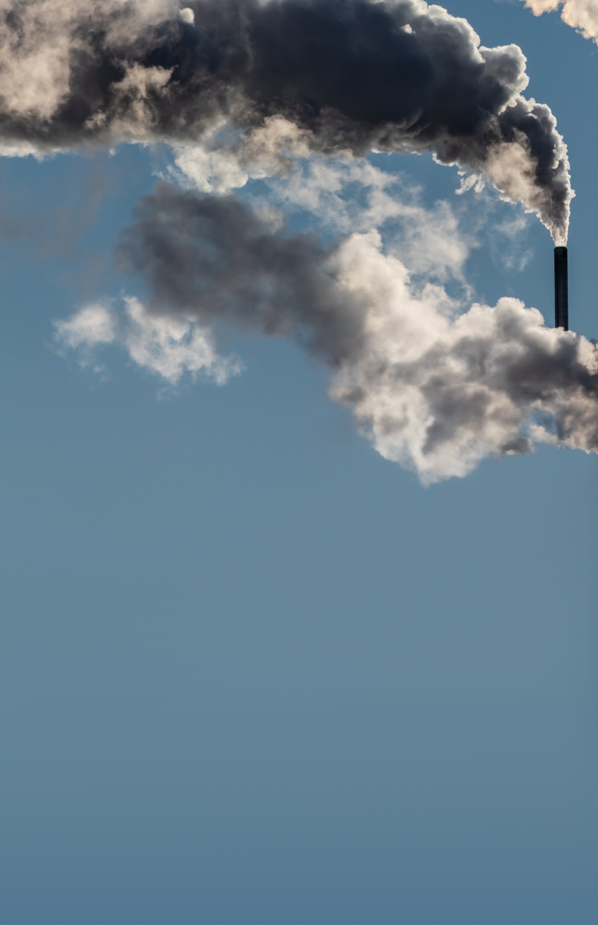 Image of smokestacks against a gray sky.